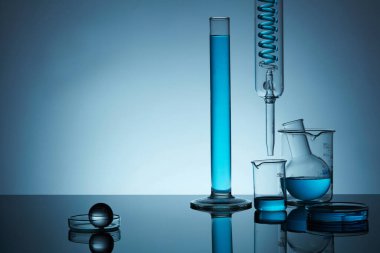 Arka planda mavi bir solüsyon içeren laboratuvar vitrininin ön görüntüsü. Ürün, metin ve tasarım için alan. Asgari konsept.