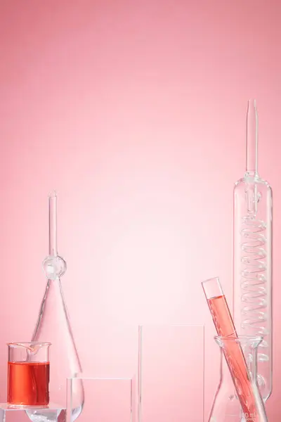 Lab theme with lab glassware filled pink liquid on pink background. Concept: research, biochemistry, nature, pharmaceutical medicine