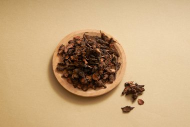 Cyperus yumrusu sahnesi kahverengi arka planda yuvarlak tabaklara konur. Cyperus tuber, öfkeyi, rahatsızlığı dindiren, regl dönemini düzenleyen, acıyı dindiren, balgamları temizleyen geleneksel bir ilaçtır.