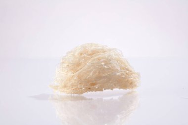 Beyaz arka planda izole edilmiş çiğ kuş yuvalarını kapatın. Doğal kaynaklı yiyecekler, sağlıklı beslenmek için pahalı mutfak malzemeleri - yaşlanma karşıtı, parlak cilt, melasyon önleme, çiller etkili bir şekilde