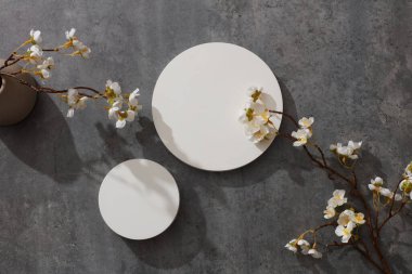 Arka planda beyaz çiçekli boş podyum. Kozmetik, ticari markalaşma ve ürün sunumu için kopya alanı olan minimal sanat arkaplanı, düz uzanma