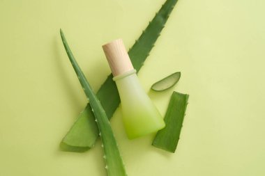 Aloe Vera yapraklarıyla süslenmiş markasız bir kozmetik kavanozu. Aloe vera (Aloe barbadensis miller) kozmetik üretiminde popüler bir malzemedir.