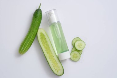 Salatalık dilimleriyle süslenmiş salatalıktan çıkarılan sıvıyla dolu pompa şişesi. Salatalık (salatalık sativus) derinin şişkinliğini ve şişkinliğini azaltma yeteneğine sahiptir..