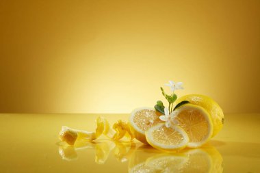 Ayna masasına sarılı küçük beyaz çiçeklerle süslenmiş limon dilimleri ve kabukları. Limon (Citrus limon) doğal cilt parlatıcı olarak bilinir.