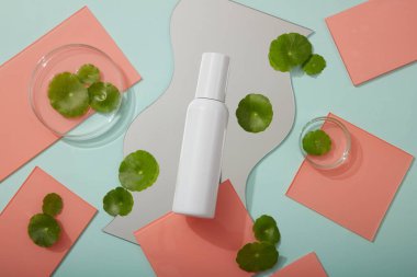 Cam petri kabı, geometrik ayna ve boş etiket şişesiyle düzenlenmiş bir sürü pembe akrilik çarşaf. Tüm cilt tipleri Gotu kola (Centella asiatica) ürününden faydalanabilir