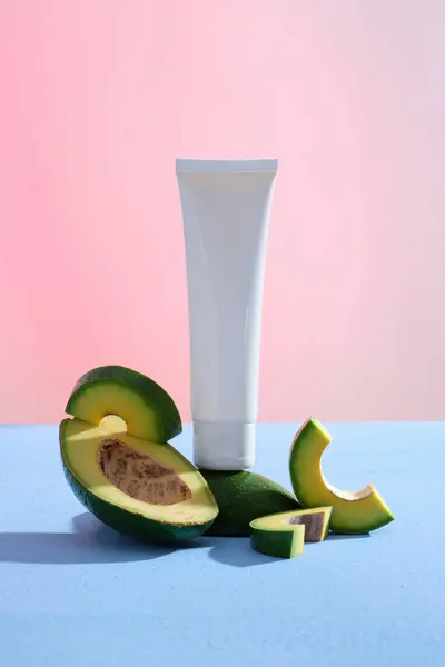 Avocadoのスライスが付いている勾配の背景で飾られる未分類の管 Avocado ペルアエルカ 皮膚に利益をもたらす化粧品生産の成分として使用することができます — ストック写真