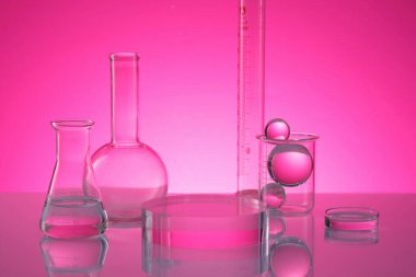 Petri kabı, erlenmeyer matarası ve ayna masasının üzerinde yuvarlak bir podyum ile düzenlenmiş düz taban florans şişesi gibi laboratuvar vitrinleri. Bilim içeriğini araştır