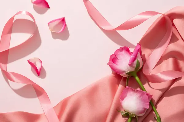 玫瑰被放置在具有粉色缎带和玫瑰花瓣的典雅的粉色面料上 从玫瑰 提取的有机产品可以在空的空间中显示 — 图库照片