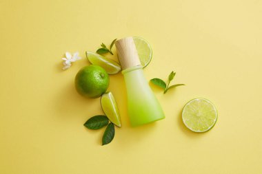 Kavanoz, yapraklar, çiçekler ve limon dilimlerinin bileşimi. Limon (Citrus aurantiifolia) sağlıklı ve parlak ciltleri geliştirmek için C vitamini içerir.