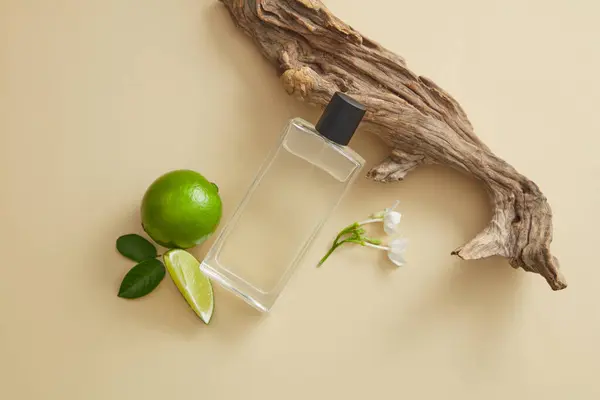 Transparent mist spray containing fluid extracted from Lime (Citrus aurantiifolia) displayed with tree branch and Lime. Lime essential oil can be used in perfume production