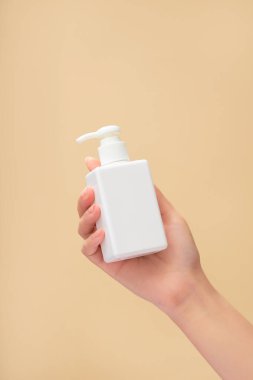 Kadın bir el mankeni boş bir pompa şişesini beyazlar içinde tutuyor. Temizleyici ya da şampuan ürünleri tanıtımı