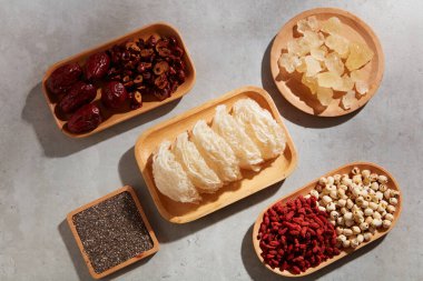 Yenilebilir kuş yuvası, chia tohumu, jujube, kaya şekeri, kurutulmuş goji üzümü ve ahşap tabaklara nilüfer tohumu. Sağlık hizmetleri için pahalı gıdalar