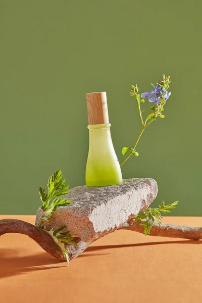 A green jar unlabeled putted on a stone. Empty label for beauty product mockup extracted from Mugwort. Mugwort (Artemisia vulgaris) is used as an ingredient in cosmetic production