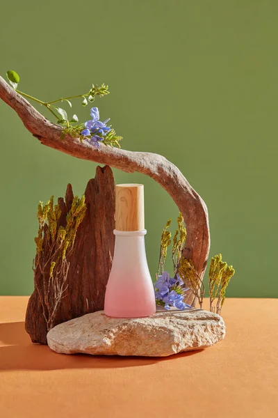 A stone with an empty label jar in pink color placed on, decorated with trees and flowers. Mugwort (Artemisia vulgaris) helps removing dirt and grime from the skin