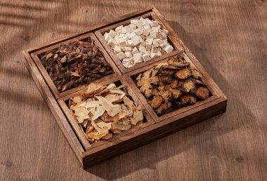 İçinde Poria cocos, Szechuan Lovage Rhizome ve diğer otlardan oluşan kare bir ahşap tepsi. Geleneksel Çin tıbbı kavramı