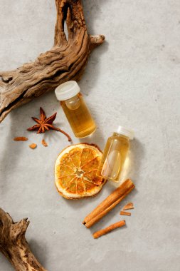 Tarçın (Tarçın), kurutulmuş portakal dilimi ve yıldız anason özü ile dolu boş şişe kavanozlarıyla süslenmiş bir ağaç dalı. Bitkiler sağlık, cilt ve saç için iyidir.