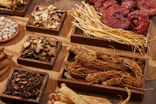 A variety of herbs are displayed on wooden trays in square and rectangle shape. Traditional chinese medicine is very precious and used to prevent or treat health problems