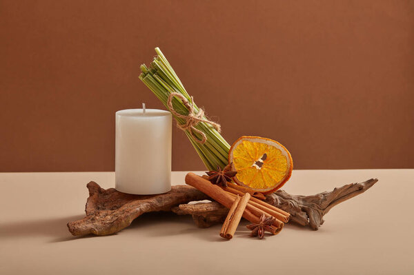 Белая свеча имеет эфирное масло, извлеченное из лимонной травы, корицы и сушеного оранжевого ломтика с пустой этикеткой. Макет продукта. Преимущества снижения стресса, расслабления и спокойного сна