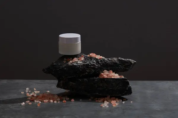 Кувшин Скраба Черном Камне Гималайской Розовой Солью Разбросанной Вокруг — стоковое фото