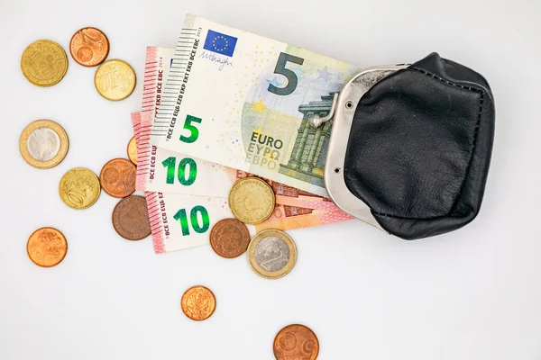 Small change in euro coins and banknotes and a small purse as a sign of poverty