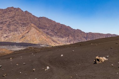 Fogo Adası, Cape Verde 'deki Pico do Fogo yanardağının eteklerindeki karanlık lav kayaları boyunca bir patika.