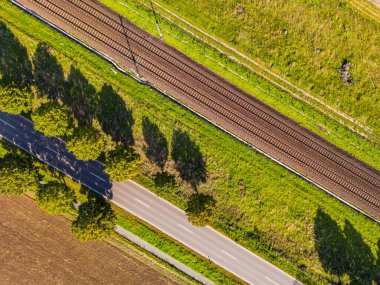 Bir yol, ağaçlar ve yukarıdan doğrudan Almanya 'ya bakan bir demiryolu hattı.