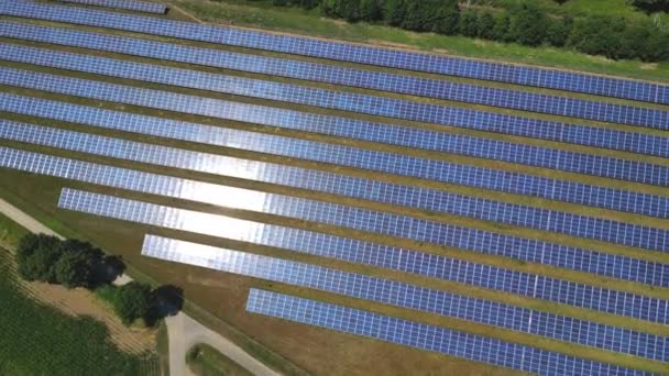 ドイツの田園地帯内の近代的なソーラーパークの青いソーラーパネルの日光と反射 — ストック動画