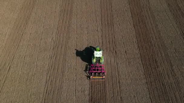 在阳光普照的棕色田野上耕地的空中观景拖拉机 犁地驱车 — 图库视频影像