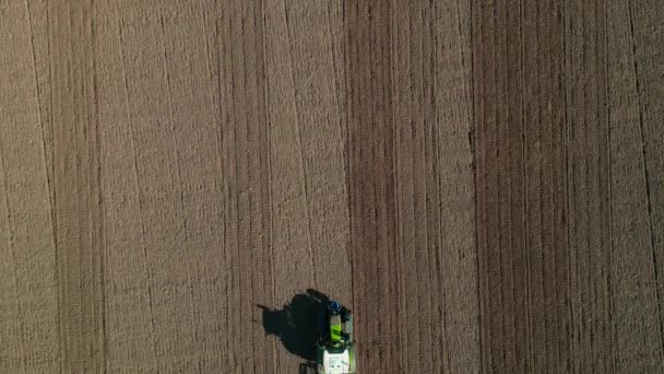 拖拉机在穿过视野的棕色田野上犁地的空中景象 — 图库视频影像