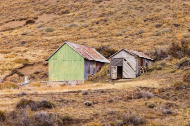 Oluklu bir demir kulübe ve ahşap bir kulübe Patagonya, Şili 'de kamp yeri ve barınak görevi görüyor.