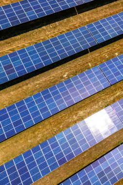 Sahada yenilenebilir enerji üretimi için bir güneş parkından gelen modüller dik bir görüntü olarak kullanılıyor.