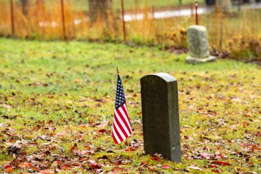 Smoky Dağları Ulusal Parkı 'ndaki Cades Koyu' nda eski bir mezar taşının yanında bir Amerikan bayrağı duruyor.