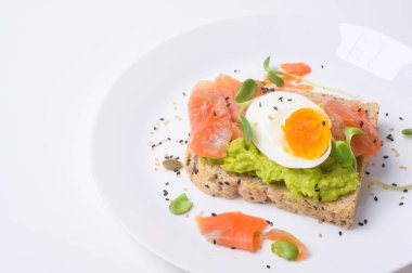 Avokadolu ekmek, sebzeli meyve ve yumurta beyaz arka planda, sağlıklı kahvaltı kavramı 