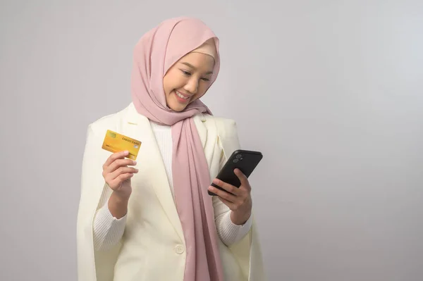 一个漂亮的穆斯林女人 头戴头巾 拿着信用卡在白色的背景工作室 购物和金融的概念 — 图库照片