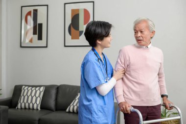 Yaşlılar Sağlık Merkezi 'nde yaşlı bir adama bakan Asyalı bir hemşire..