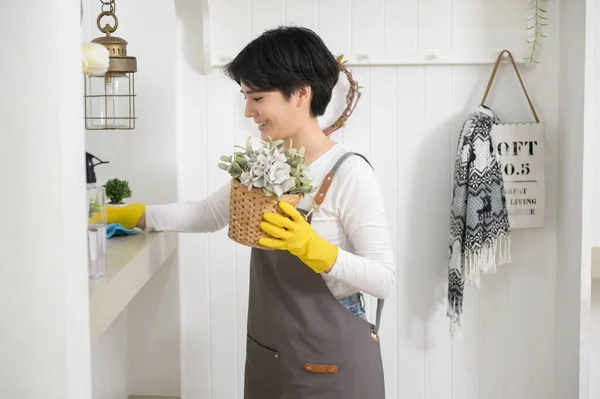家を掃除するためにアルコールスプレー消毒剤を使用して手袋を掃除しているアジアの女性 健康的なライフスタイルのコンセプト — ストック写真