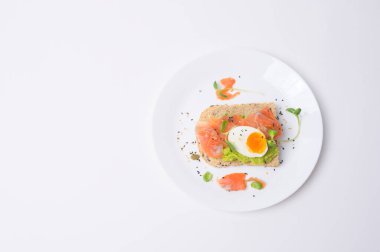 Avokadolu ekmek, sebzeli meyve ve yumurta beyaz arka planda, sağlıklı kahvaltı kavramı 