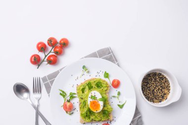 Avokadolu ekmek, sebzeli meyve ve yumurta beyaz arka planda, sağlıklı kahvaltı kavramı 