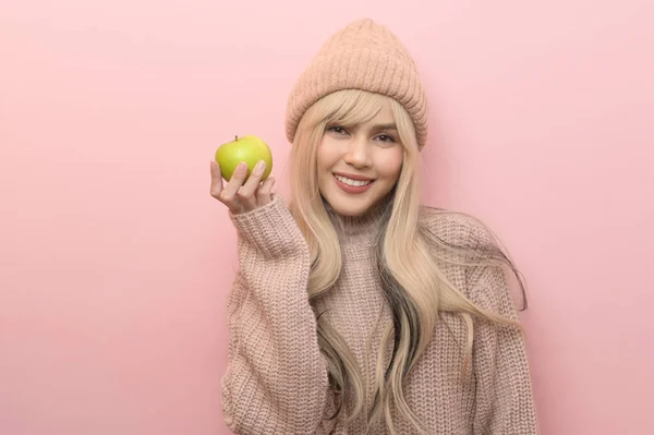 白种人年轻女性穿着粉色背景的绿色苹果毛衣的肖像 — 图库照片
