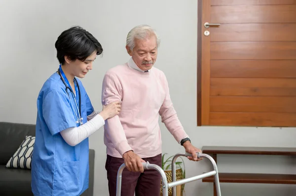 An Asian nurse taking care of an elderly man with walker at senior healthcare center.