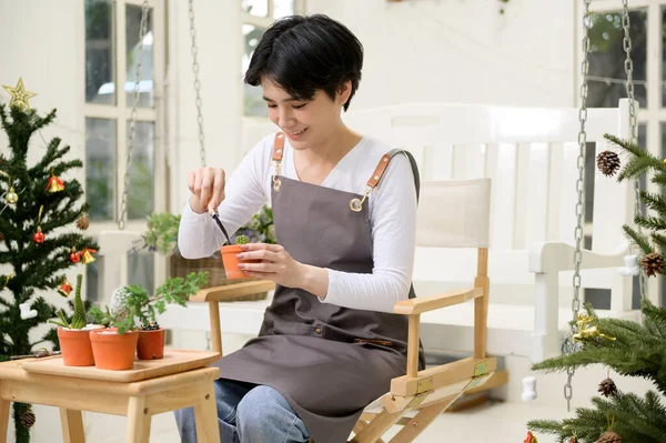 A young Asian woman enjoys gardening at home, Health care and wellbeing concept