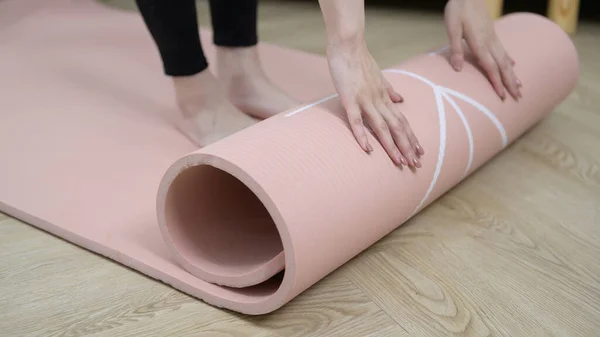 stock image Close-up of a young woman's hand holding a fitness mat, home training, and the concept of a healthy lifestyle.