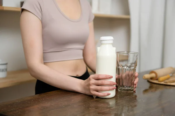 家庭で台所で牛乳を飲むスポーツウェアのアジアの若い女性 健康的なライフスタイルの概念 — ストック写真