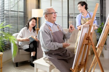 Asyalı son sınıf öğrencileri yaşlılar sağlık merkezinde resim yapmaktan zevk alıyor, yaşlılar grup terapisi