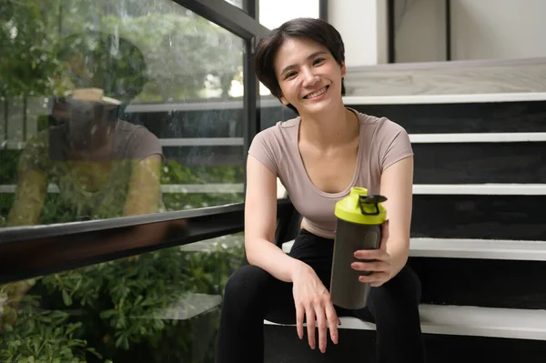 Asyalı Genç Bir Kadın Protein Takviyesi Içiyor Evde Egzersiz Yapıyor — Stok fotoğraf