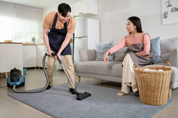 young Asian couple cleaning home feeling bored , exhausted with dirty home