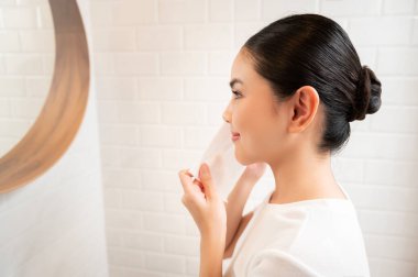 Evde, banyoda makyajını temizleyen genç bir kadın. Güzellik anlayışı. 