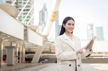 Modern şehirde tablet kullanan güzel bir iş kadınının portresi.