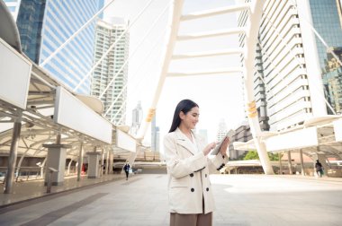 Modern şehirde tablet kullanan güzel bir iş kadınının portresi.