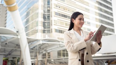 Modern şehirde tablet kullanan güzel bir iş kadınının portresi.